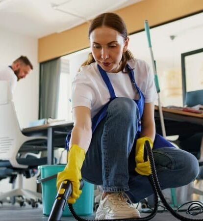 Mitarbeiterin reinigt Büroteppich mit Dampfreiniger für allergenfreie, hygienische Arbeitsräume.